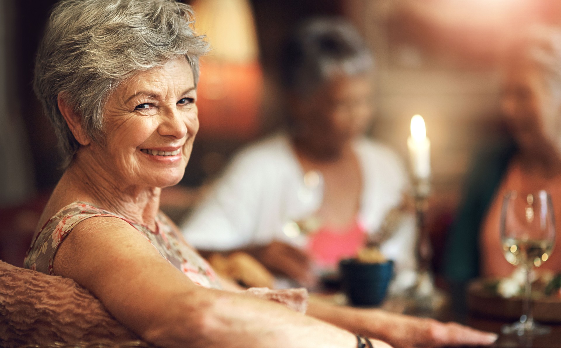 Assisted living, portrait and smile of senior woman in retirement home with friends for social gathering. Face, happy or relax and elderly people in apartment together for dinner, hunger or meal